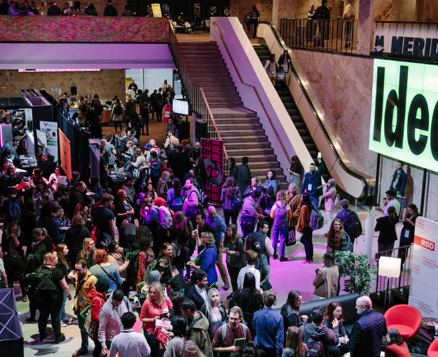 The atrium at DesignThinkers Toronto filled with people milling about.