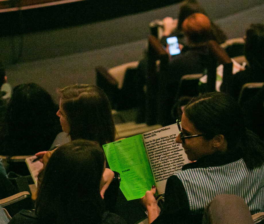 People reading a program at DesignThinkers Toronto.